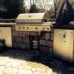 outdoor kitchen with stone patio by Hudson Valley Property Maintenance